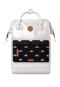 Weißer rechteckiger Rucksack mit einer schwarzen Vorderseite, die mit gelben Sonnenmotiven gestaltet ist, sowie zwei oberen Tragegriffen.