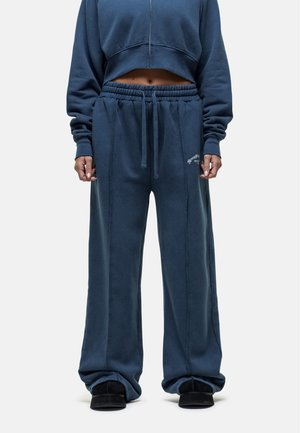 Blauwe korte trui en bijpassende brede sweatpants van zachte stof, met een elastische tailleband en gestikte details.