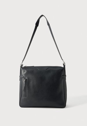 Sac à bandoulière noir en cuir grainé, doté d’une longue bandoulière réglable, de clips couleur argent, de boucles latérales et d’une fermeture éclair sur le dessus.