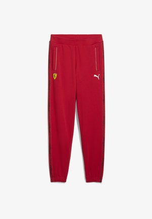 Rode joggingsbroek van zacht materiaal. Voorzien van zijzakken, elastische boorden en zwarte zijstrepen met merklijen. Ferrari-embleem aan de voorkant.