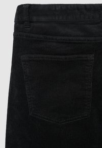 Schwarzer Cord-Stoff mit vertikalen Rippungen, ausgestattet mit einer einzelnen Gesäßtasche und einem Bund oben. Die Textur ist weich und ausgeprägt.