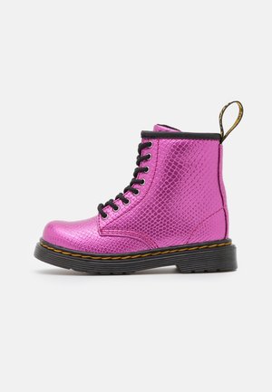 Klar pink ankelstøvle med tekstureret mønster, sorte snørebånd, sort sål med gul syning og en sort og gul træksløjfe bagpå.