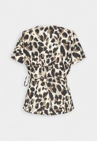 Blouse manches courtes avec imprimé léopard beige, marron et noir et une fine ceinture nouée à la taille.