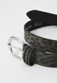 Opasok s leopardím vzorom vyrobený z textúrovanej látky, so striebornou kovovou prackou a detailmi prešitými okrajmi. Farebná paleta zahŕňa sivú a hnedú.