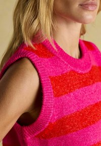 Ärmelloser Strickpullover mit horizontalen Streifen in Pink und Rot. Strukturierter Stoff mit geripptem Ausschnitt und Armausschnitten.