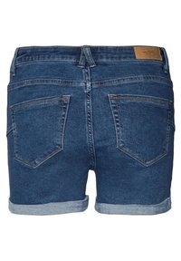 Jeansshorts i mörkblått med uppvikt nederkant. Har en slät yta, fem fickor och en brun läderetikett vid midjan.