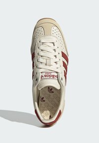 Bijele kožne tenisice s bordo suknjenim trakama, perforiranim detaljima, vezanjem sprijeda i ušivenim uloškom s uzorkom koji prikazuje adidas logo.