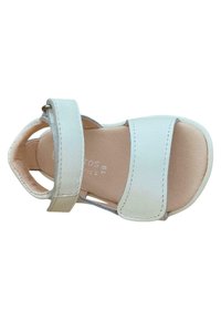 Sandalia de cuero blanco con dos tiras anchas, diseño de talón abierto y plantilla beige texturizada. Presenta costuras ligeras a lo largo de las tiras.