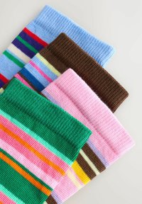 Patru șosete tricotate pliate, cu dungi orizontale colorate în nuanțe de albastru, maro, roz și verde, pe o suprafață albă.