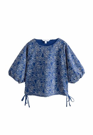 Blue blouse with puff sleeves, featuring a wavy white line pattern. Drawstring ties at the hem enhance fit. Smooth fabric texture.