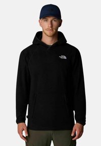 Felpa nera con cappuccio, dotata di tasca a marsupio e logo The North Face bianco sul petto, realizzata in un morbido tessuto testurizzato.