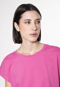 Roze t-shirt met korte mouwen en een ronde halslijn, gemaakt van zachte stof, met een gladde textuur en een ontspannen pasvorm.