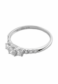Strieborný prsteň so piatimi diamantmi rôznych brúsení, zasadenými do hladkého pásika. Diamanty sú výrazné s lesklým, reflektujúcim povrchom.