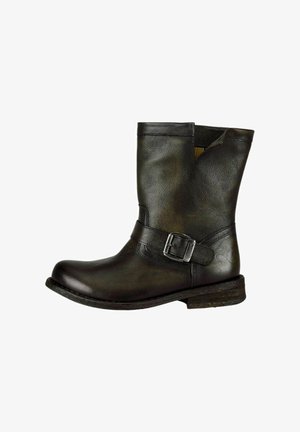Bottine en cuir noir avec un bout rond, détail de boucle sur le côté et finition texturée. Talon bas empilé et léger revers en haut.