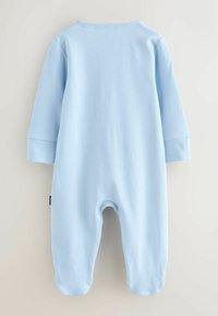 Gaiši zils kokvilnas kombinezons ar garām piedurknēm, aplokšķērsmēm un piegriezumu apkaklītei. Audumam ir gluda tekstūra bez redzamām rakstu zīmēm.