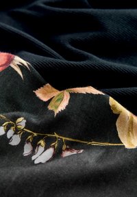 Blommig tyg med en svart bakgrund och färgglada, detaljerade blommor och blad i nyanser av rosa, grönt och gult. Mjuk textur.