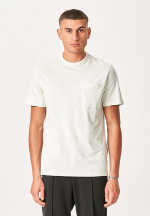 Lys grå kortærmet t-shirt med rund halsudskæring og en lomme på venstre bryst. Fremstillet af blødt stof, der har en glat tekstur.