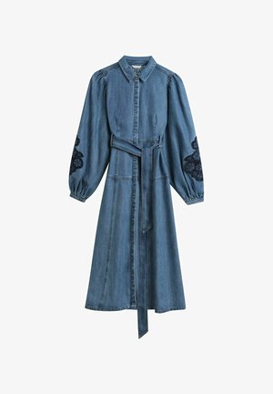 Robe longue en denim avec manches longues bouffantes, broderie florale noire sur les coudes, devant boutonné et ceinture nouée à la taille.