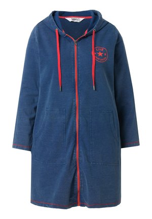 Blauwe sweatjurk met capuchon en rits, rode trekkoorden, rode rits, zakken aan de voorkant en een sterembleem met de tekst "Live Your Dream" op de borst.