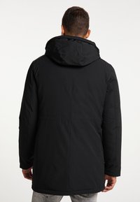 Sort hættetrøje med lige skæring, der har en glat overflade og minimalistisk design. Der er ingen synlige mønstre eller hardware-detaljer.