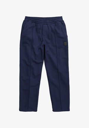 Marineblaue Jogginghose aus Fleece mit elastischem Bund, seitlichen Taschen und abgesteppten Frontnähten.