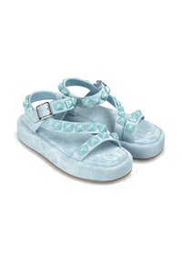 Sandali platform blu chiaro con texture opaca, caratterizzati da borchie decorative lungo le cinghie e una fibbia regolabile per una vestibilità ottimale.