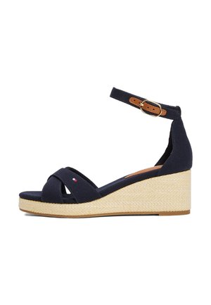 Sandalias cuña de lona azul marino con correas cruzadas, correa en el tobillo y hebilla de cuero sintético marrón. Presenta una suela de fibra natural texturizada.