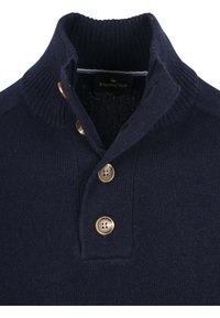 Marineblauwe gebreide trui met een geribbeld kraagje, voorzien van drie gouden knopen en een label met de tekst "STEPPIN' OUT." Zachte textuur.