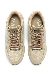 Zapatillas deportivas beiges con una parte superior de malla y cuero, acentos dorados y un sistema de cordones con patrón. Cuenta con una plantilla acolchada.