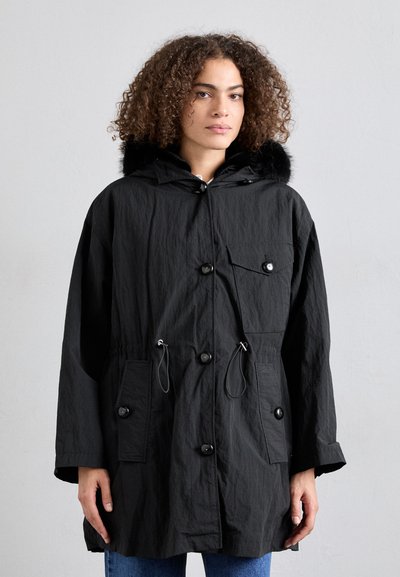 Sort parka-jakke lavet af tekstureret stof, med en pelsforet hætte, frontknapper og to sidelommer med justerbar snoreliv.