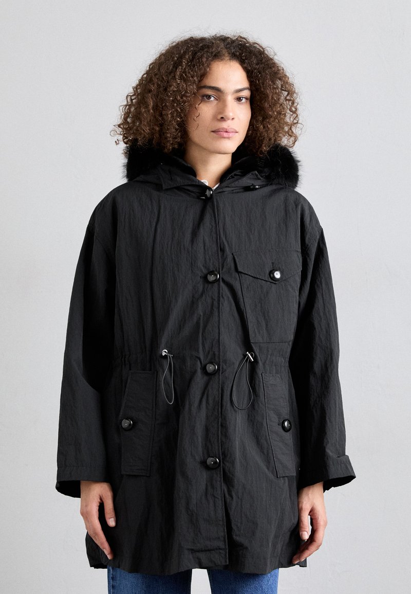Black parka jacket made of textured fabric, featuring a fur-lined hood, front buttons, and dual side pockets with drawstring waist adjustment.