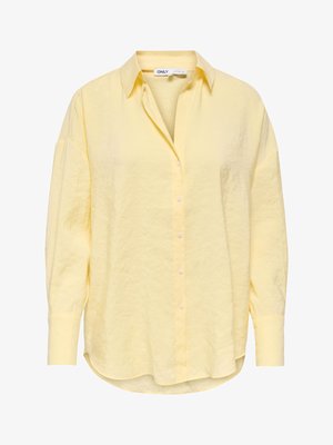 Košulja s dugim rukavima i kopčanjem na gumbe u blijedo žutoj boji, s ovratnikom, spuštenim ramenima i blago zaobljenim rubom, izrađena od teksturiranog materijala.