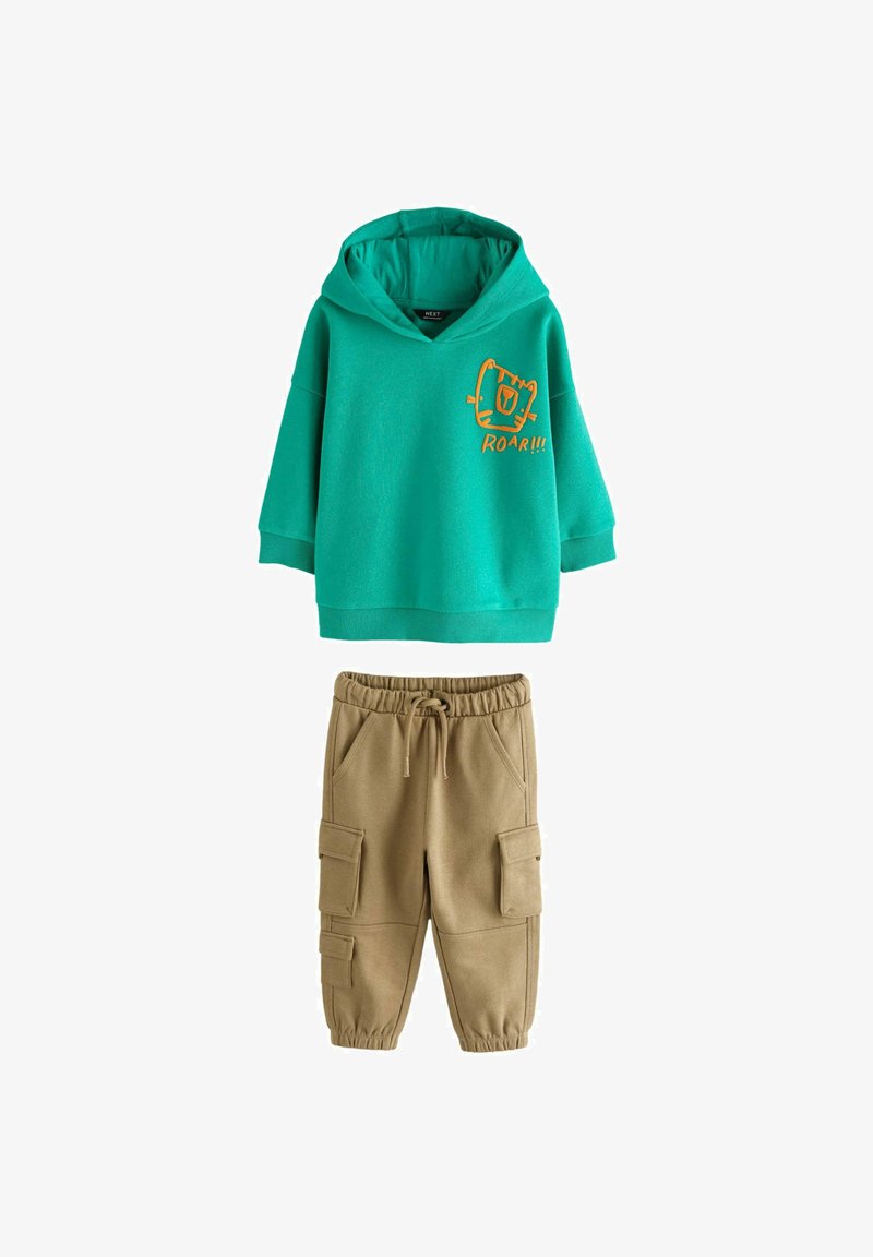 Green hoodie with orange "ROAR!!!" graphic, featuring a loose fit and kangaroo pocket, paired with khaki cargo pants with pockets and elastic waist.