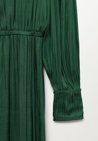 Robe longue manches longues vert foncé en tissu plissé, taille élastique et larges poignets plissés.