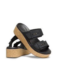 Sandales à plateforme noires avec une semelle en liège, deux sangles ajustables et des clous dorés sur les sangles. Semelle intérieure texturée pour le confort.