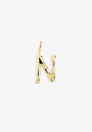 Pendentif en métal doré en forme de lettre "N" avec un design fluide et organique ainsi qu'une surface polie. Il possède une boucle pour l'attachement.