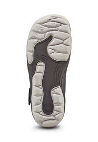Dunkelbraune Schuhsohle mit strukturierten Rillen, weißen Gummiakzenten und einem verspielten Affengesicht-Logo. Entworfen für Grip und Komfort.