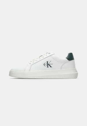 Sneaker bassa bianca Calvin Klein con linguetta nera sul tallone e logo di lato, suola bianca piatta e lacci bianchi, vista dal lato sinistro.