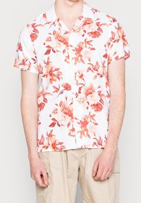 Camicia a maniche corte con una base bianca decorata da grandi motivi floreali nei toni del corallo e pesca. Chiusura con bottoni sul davanti e colletto.