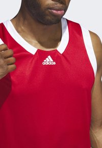 Rotes Sporttrikot mit weißen Akzenten und V-Ausschnitt. Hergestellt aus glattem, atmungsaktivem Material. Mit dem Adidas-Logo in Weiß.