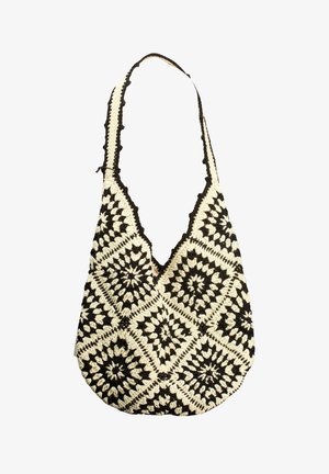 Sac d'épaule crocheté en noir et blanc avec des motifs carrés géométriques et une longue sangle.