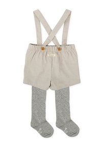 Shorts enbeige à carreaux avec des bretelles croisées et deux boutons en bois, assortis à des collants en maille grise. Étiquette visible sur les shorts.