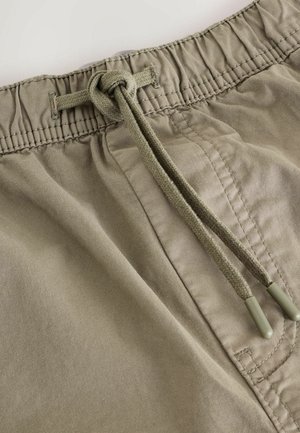 Pantalones cortos caqui con cintura ajustable mediante un cordón verde olivo, textura de tela suave y cinturilla elástica para mayor comodidad.