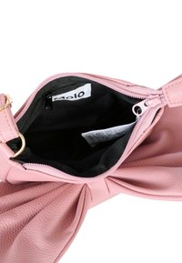 Borsa in tessuto rosa con dettaglio a fiocco, cerniera aperta che rivela l'interno foderato in nero e una piccola tasca con zip interna con etichetta.