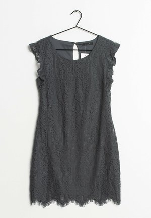 Schwarzes ärmelloses Spitzenkleid mit gewelltem Saum und kurzen Ärmeln, aufgehängt an einem schwarzen Kleiderbügel vor weißem Hintergrund.