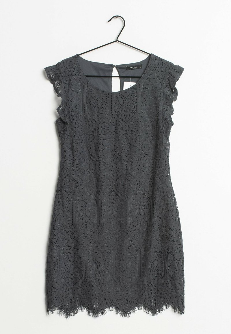 Robe sans manches en dentelle noire avec ourlet festonné et manches courtes, suspendue à un cintre noir sur un fond blanc.