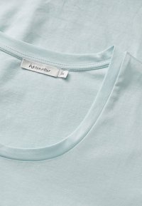 Light blue short-sleeve t-shirt with a crew neckline. Soft, smooth texture. Label reads "hessnatur" with size 36. No notable patterns or accents.