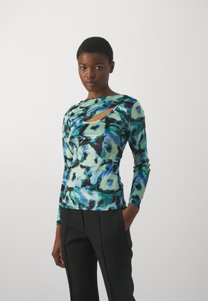 Langermet topp med et fargerikt blått og grønt abstrakt mønster, med et avvikende utskjæringsdetalj ved halsen og en tettsittende design.