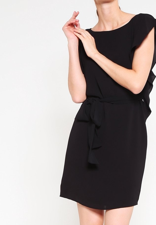 Robe noire mi-longue en tissu doux. Elle présente un décolleté rond, des manches courtes flottantes et une ceinture à la taille pour un ajustement.