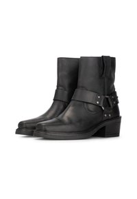 Bottines en cuir noir avec un bout légèrement pointu, une large sangle et des accents métalliques, et un petit talon empilé. Texture lisse avec un minimum de coutures.